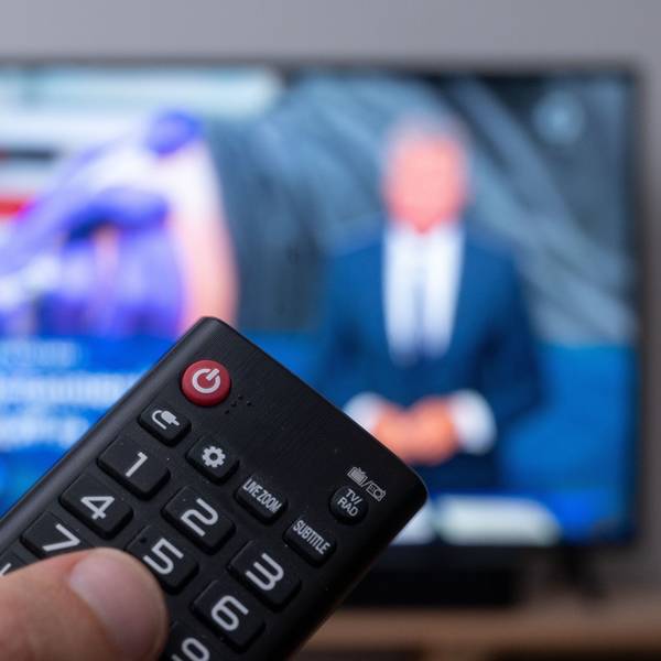 Ein Mann mit Fernbedienung vor einem Fernseher