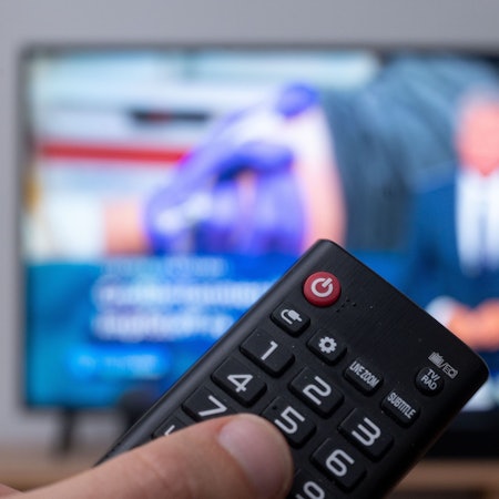 Ein Mann mit Fernbedienung vor einem Fernseher