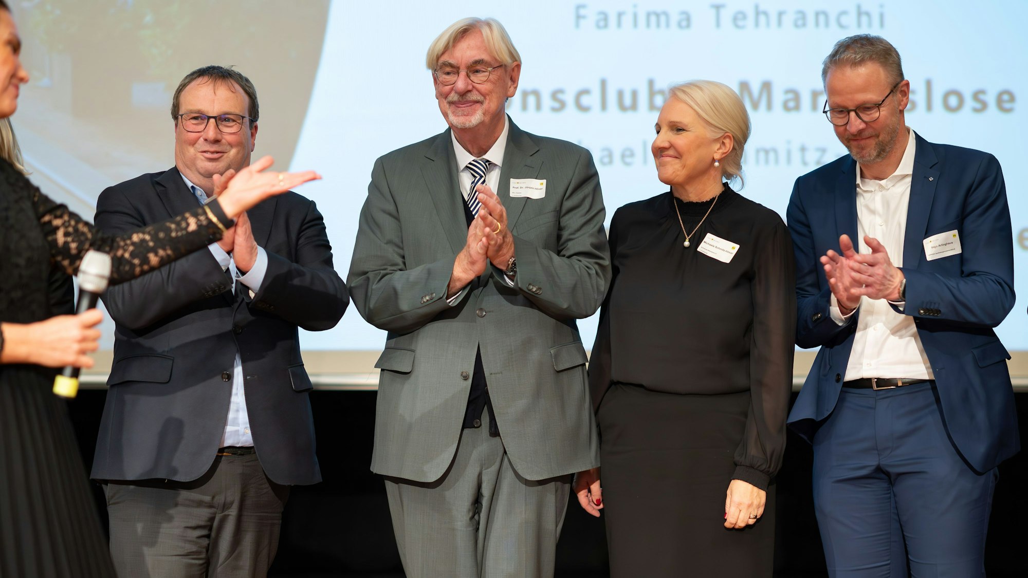 Auf dem Bild sind Männer und Frauen zu sehen, die den Wechsel eines Vereinsvorsitzes feiern.