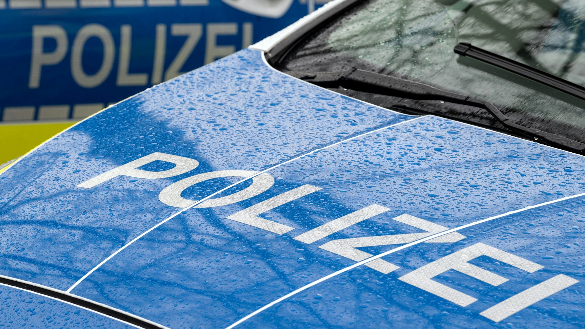 Das Foto zeigt den Schriftzug „Polizei“ auf einem Einsatzwagen.