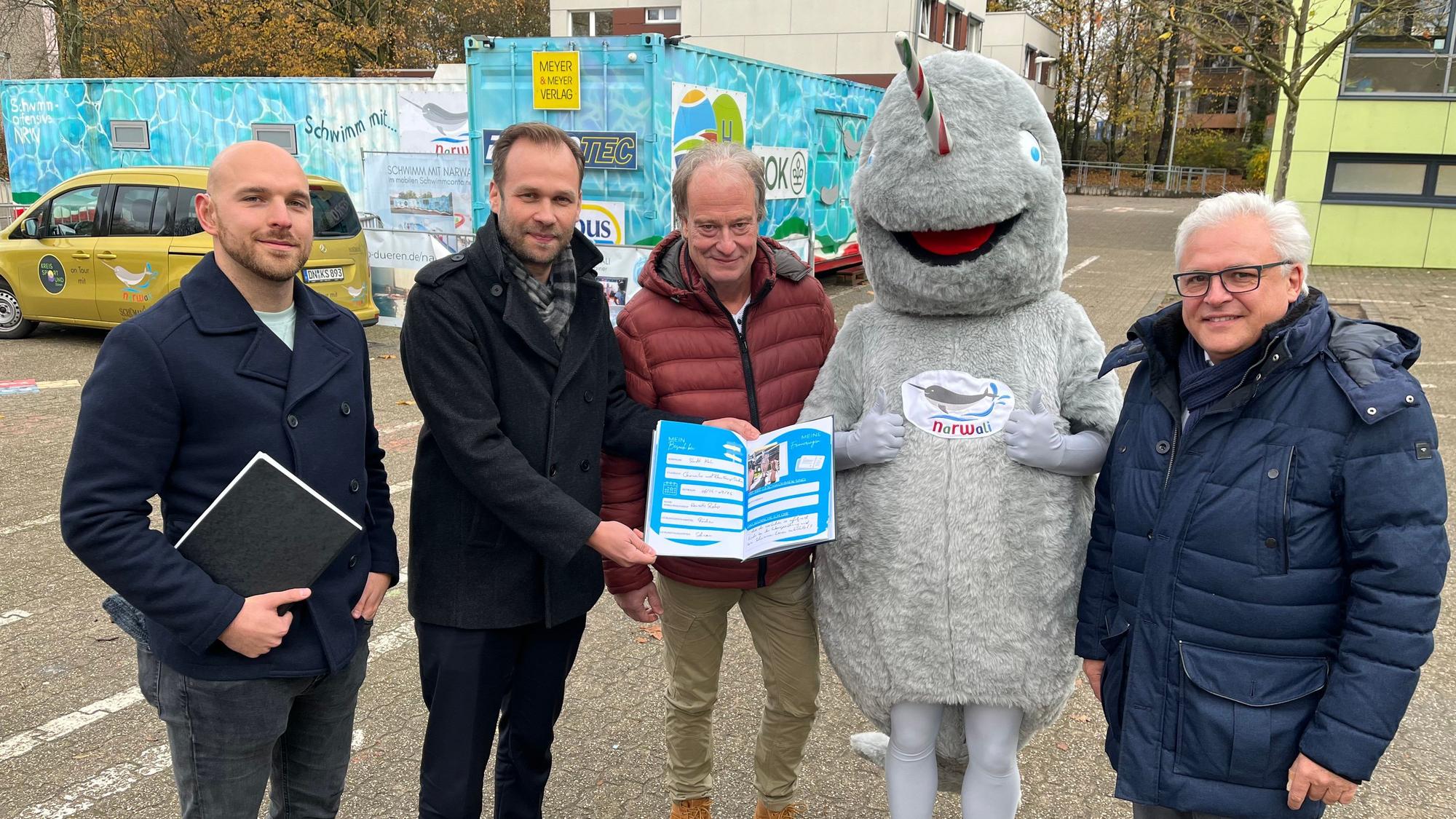 Männer mit Buch vor Schwimmcontainer