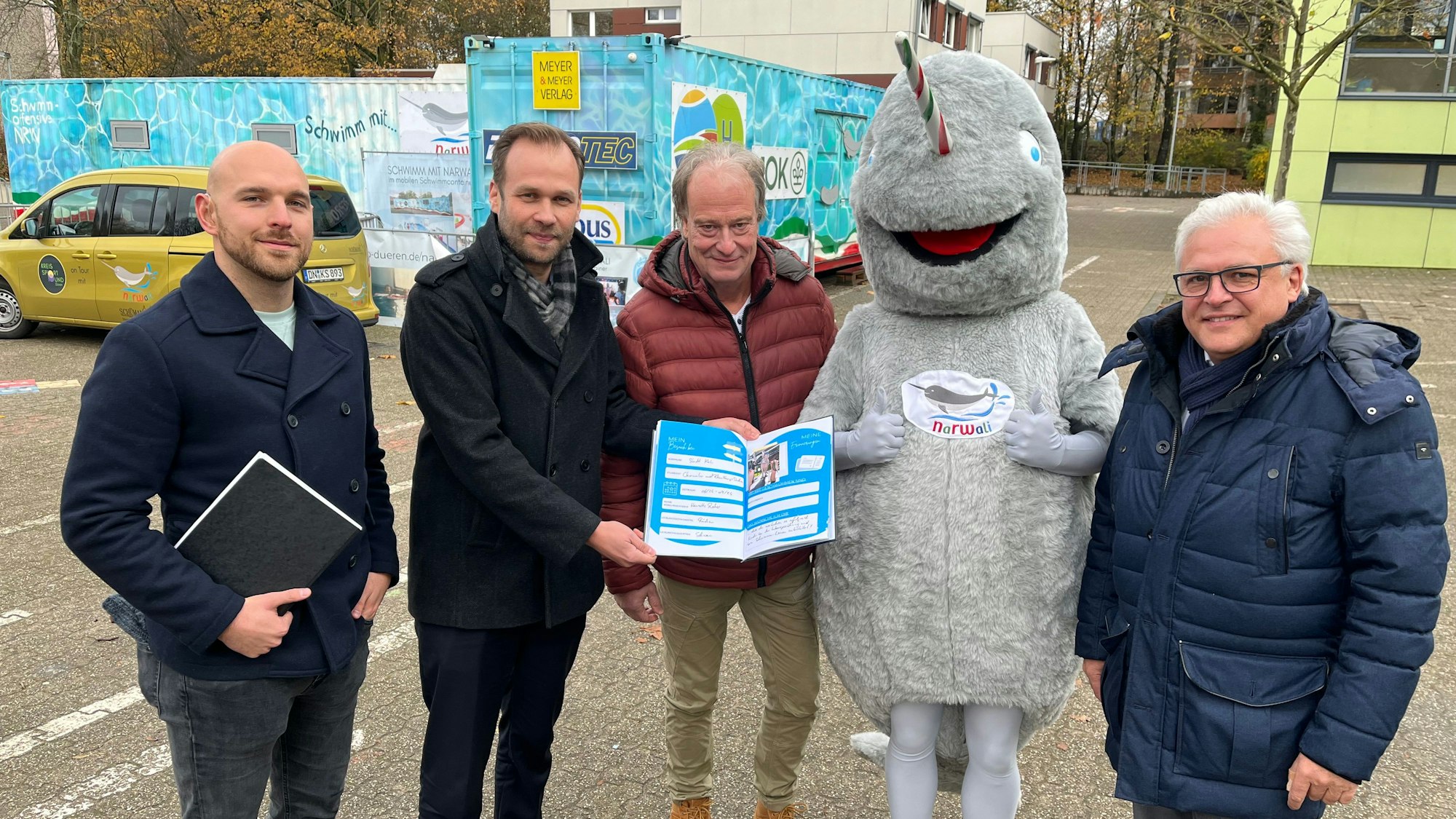Männer mit Buch vor Schwimmcontainer