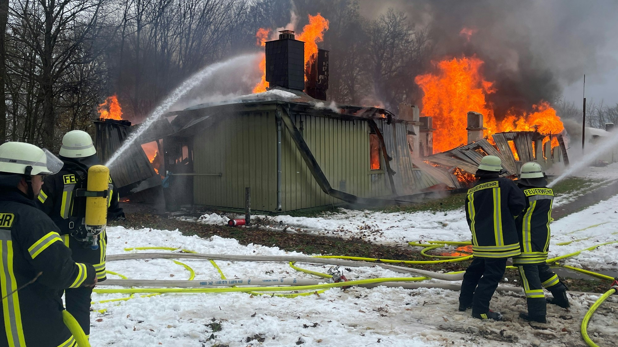 Kräfte der Schleidener Feuerwehr löschen einen Brand in einem Gebäude der Flüchtlingsunterkunft in Vogelsang.