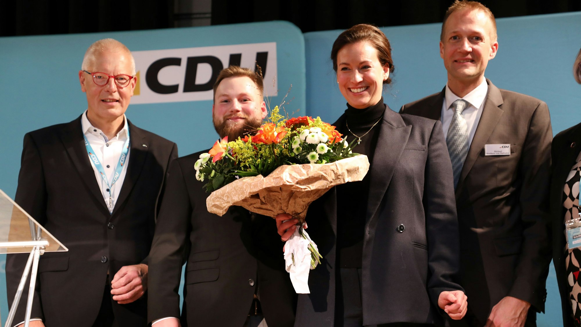 Die frischgewählte CDU-Bundestagskandidatin Caroline Bosbach steht mit ihren Mitbewerbern Michael Freiherr von Maltzahn und Fabian Felder sowie dem CDU-Kreisvorsitzenden Dr. Hermann-Josef Tebroke auf einer Bühne im Bürgerzentrum Steinbreche in Bergisch Gladbach-Refrath.