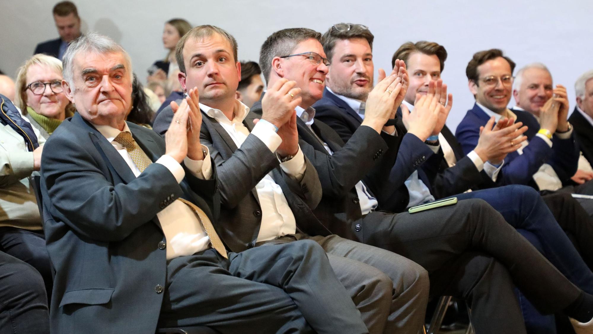 NRW-Innenminister und MdL Herbert Reul, sein Landtagsabgeordnetenkollege Martin Lucke, Landrat Stephan Santelmann, CDU-Kreistagsfraktionschef Uwe Pakendorf, CDU-Landratskandidat Arne von Boetticher und Bergisch Gladbachs CDU/FDP-Bürgermeisterkandidat Alexander Felsch sitzen und klatschen.