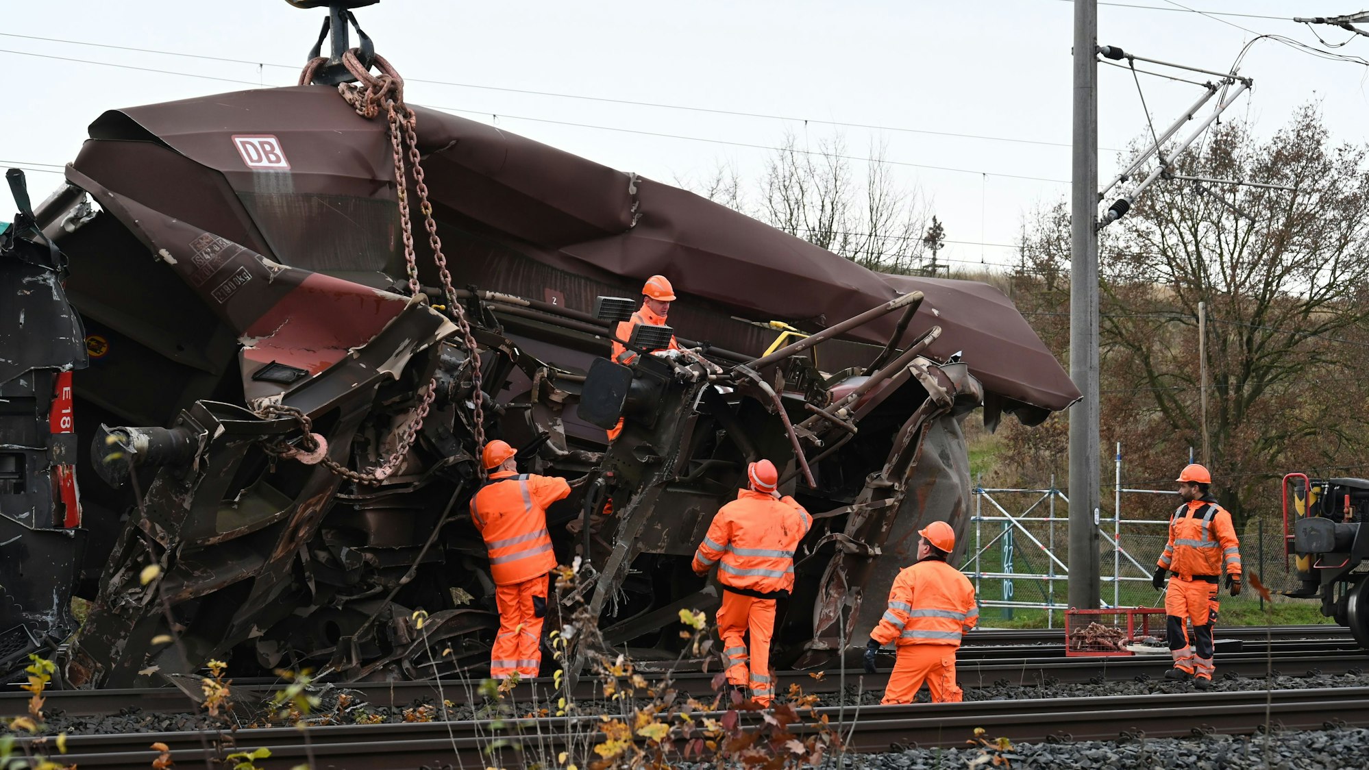 Das Bild zeigt mehrere Arbeiter an einem verunglückten Waggon.