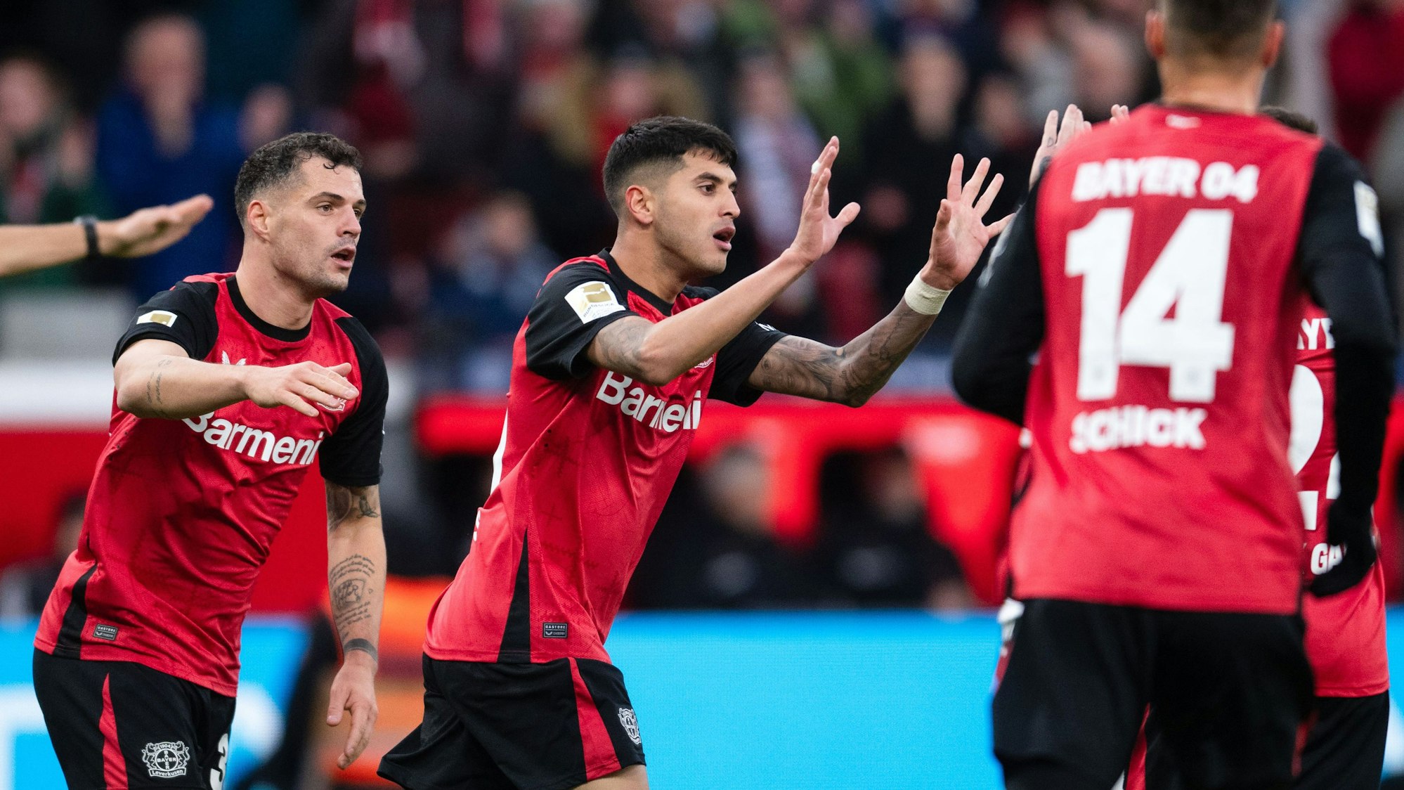 Leverkusens Granit Xhaka (l-r) jubelt mit Torschütze Exequiel Palacios über das 1:2. Daneben geht Leverkusens Patrik Schick.