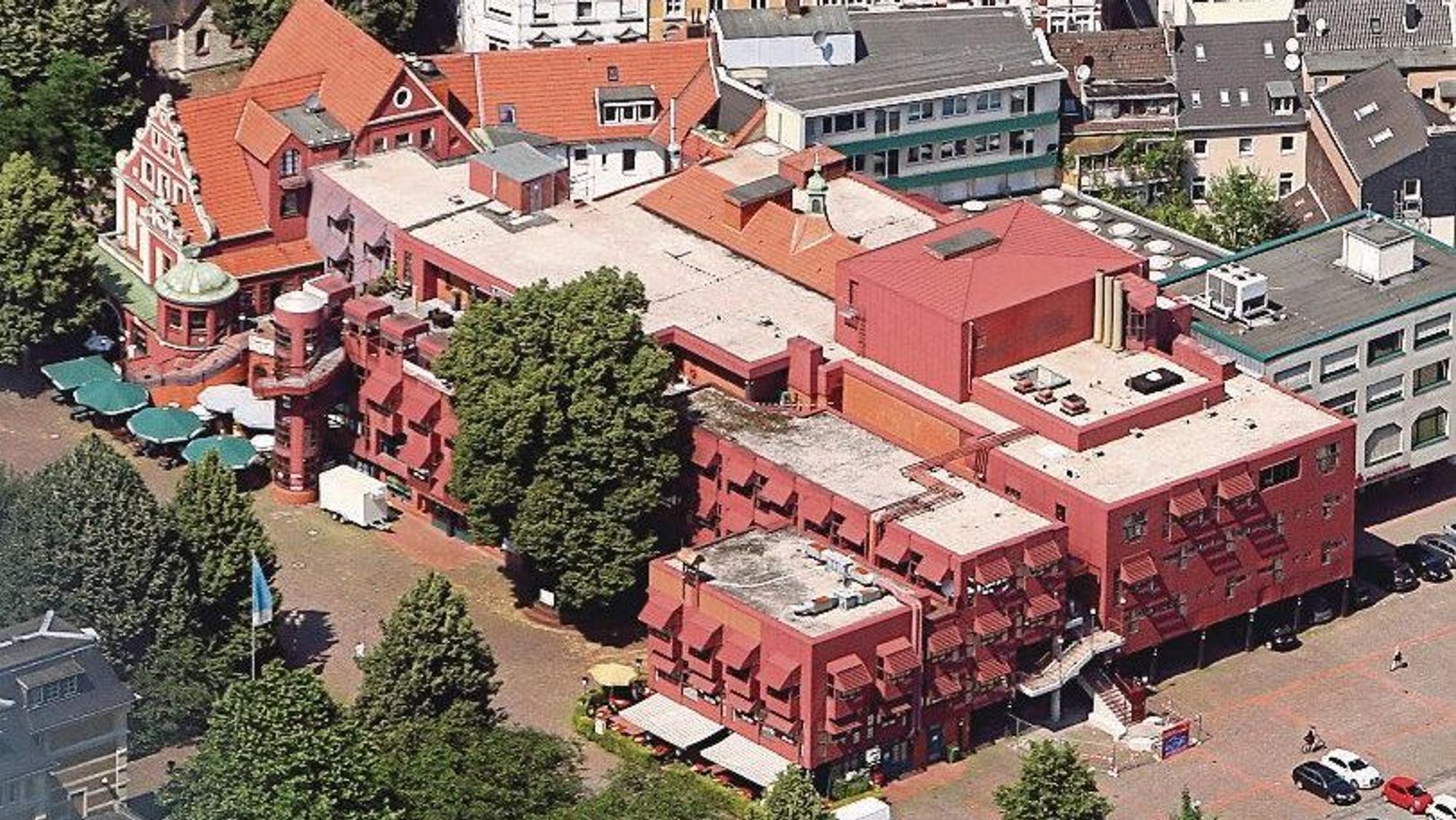 Die Luftaufnahme des Gebäudekomplexes zeigt die roten Metalllackierungen der Fassade.