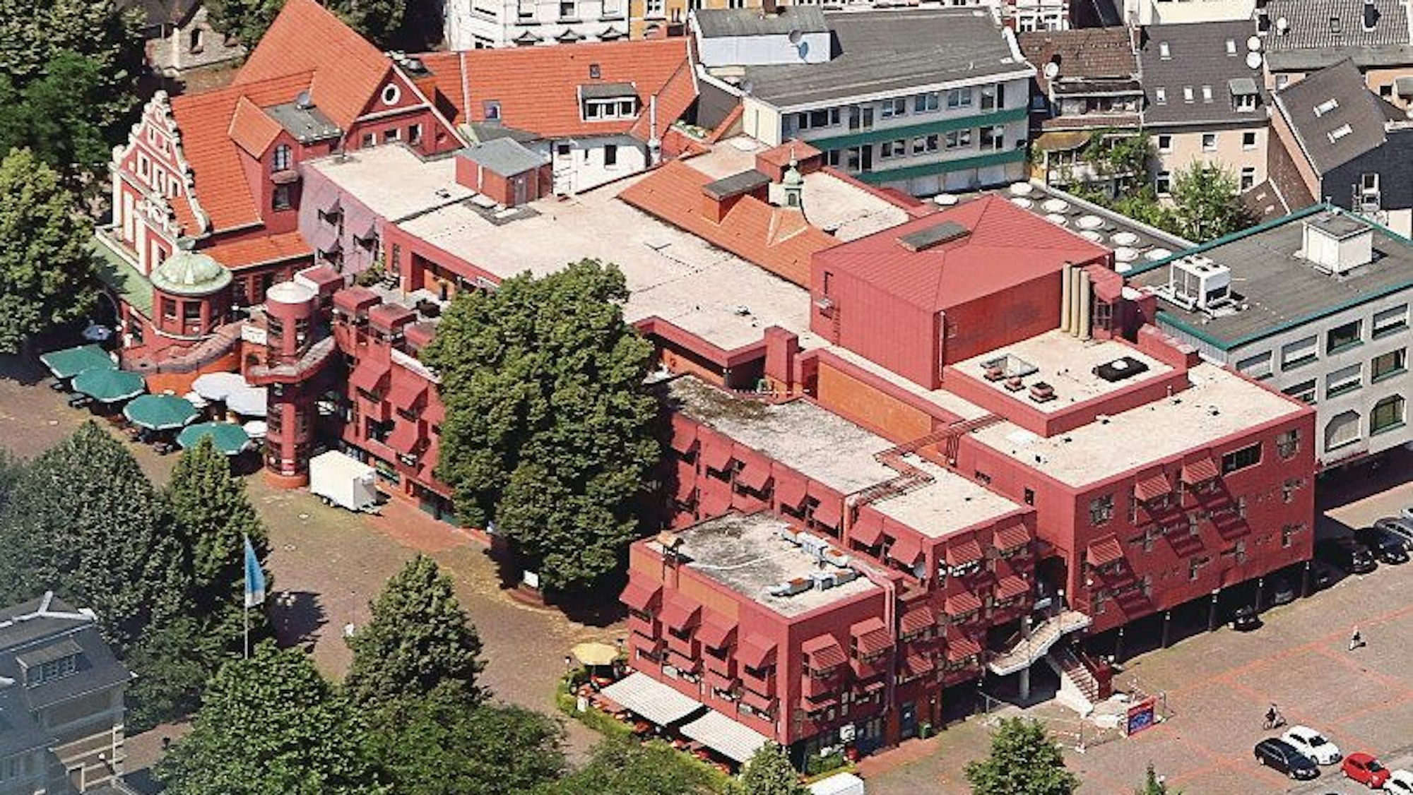 Die Luftaufnahme des Gebäudekomplexes zeigt die roten Metalllackierungen der Fassade.