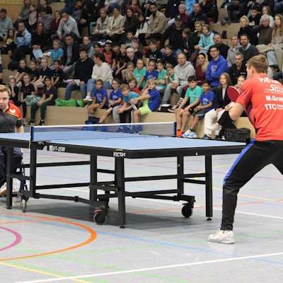 Ein Mann im Rollstuhl spielt gegen einen Stehenden.