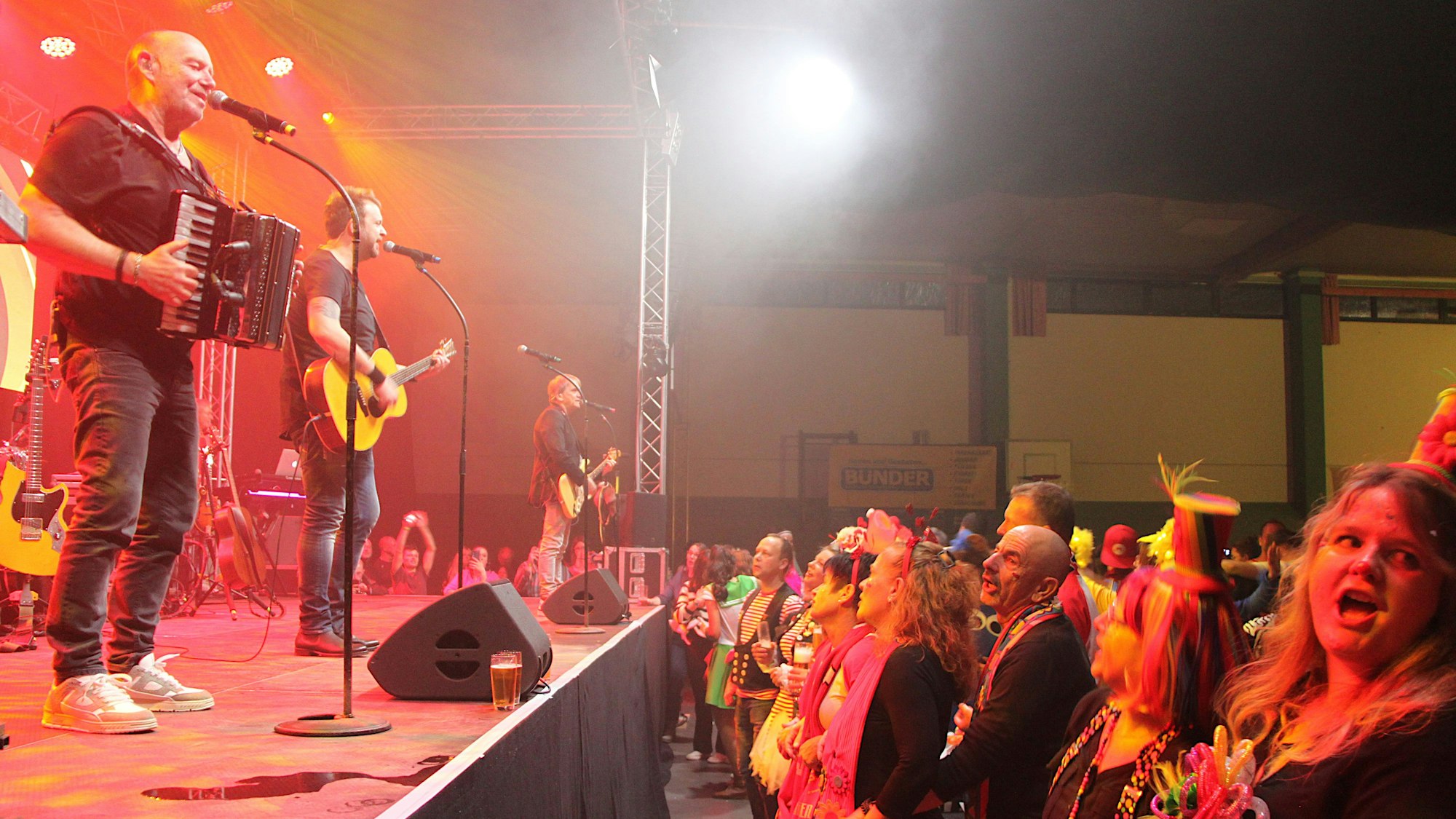 Die Paveier stehen auf der Bühne, die Fans schunkelndavor.
