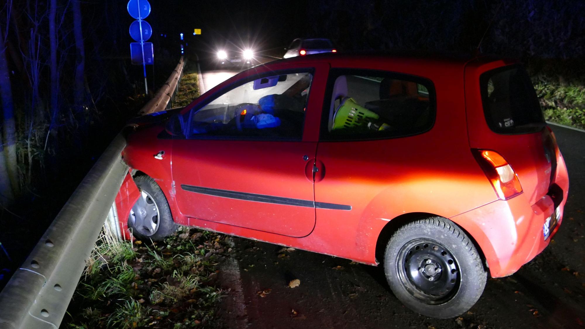 Ein Auto steht an einer Schutzplanke, die Front ist eingedrückt.