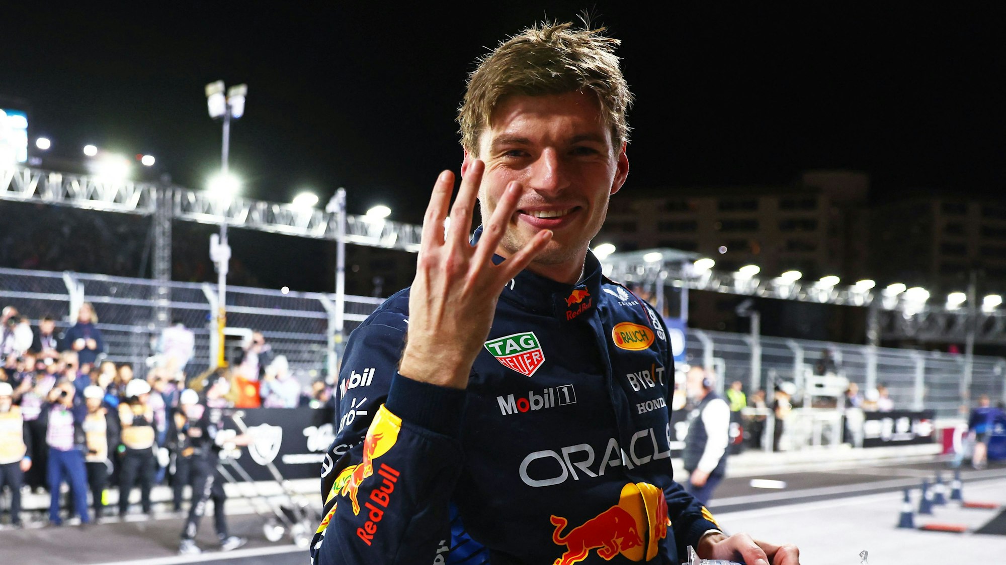 Max Verstappen zeigt vier Finger für vier Titel in die Kamera.