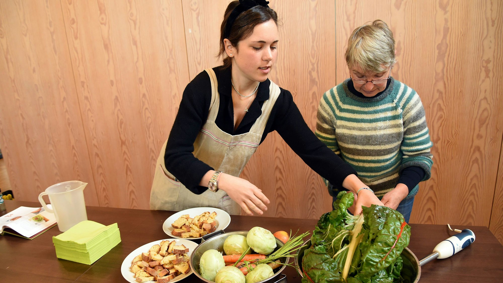 Das Foto zeigt zwei Frauen mit Gemüse.