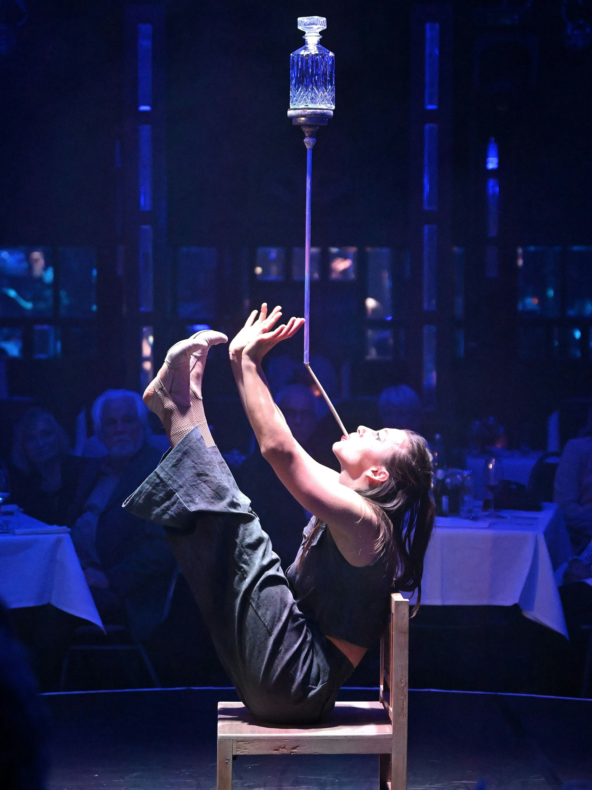 Eine Frau balanciert eine Flasche auf einer Stange.