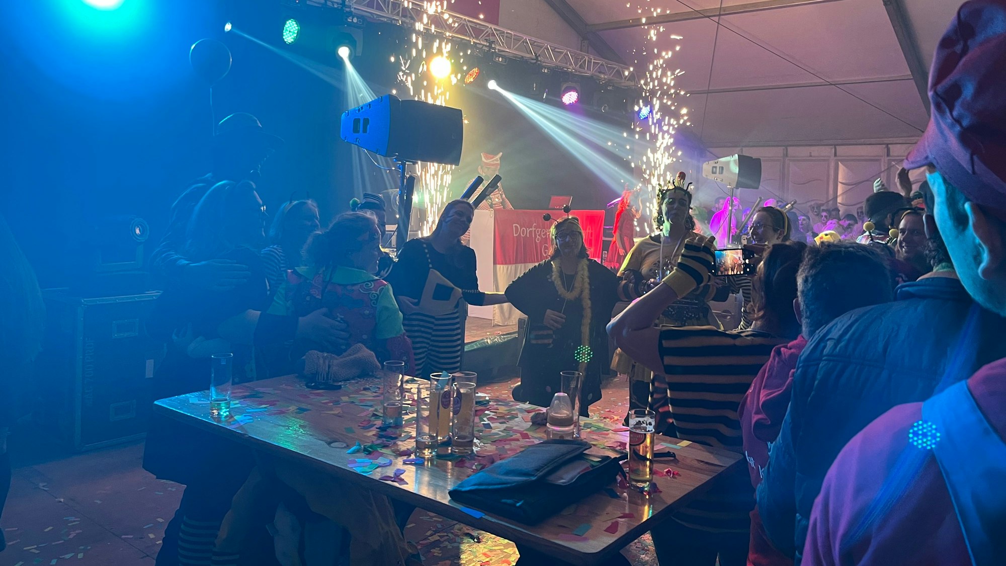 Verkleidete Frauen und Männer in einem Festzelt.