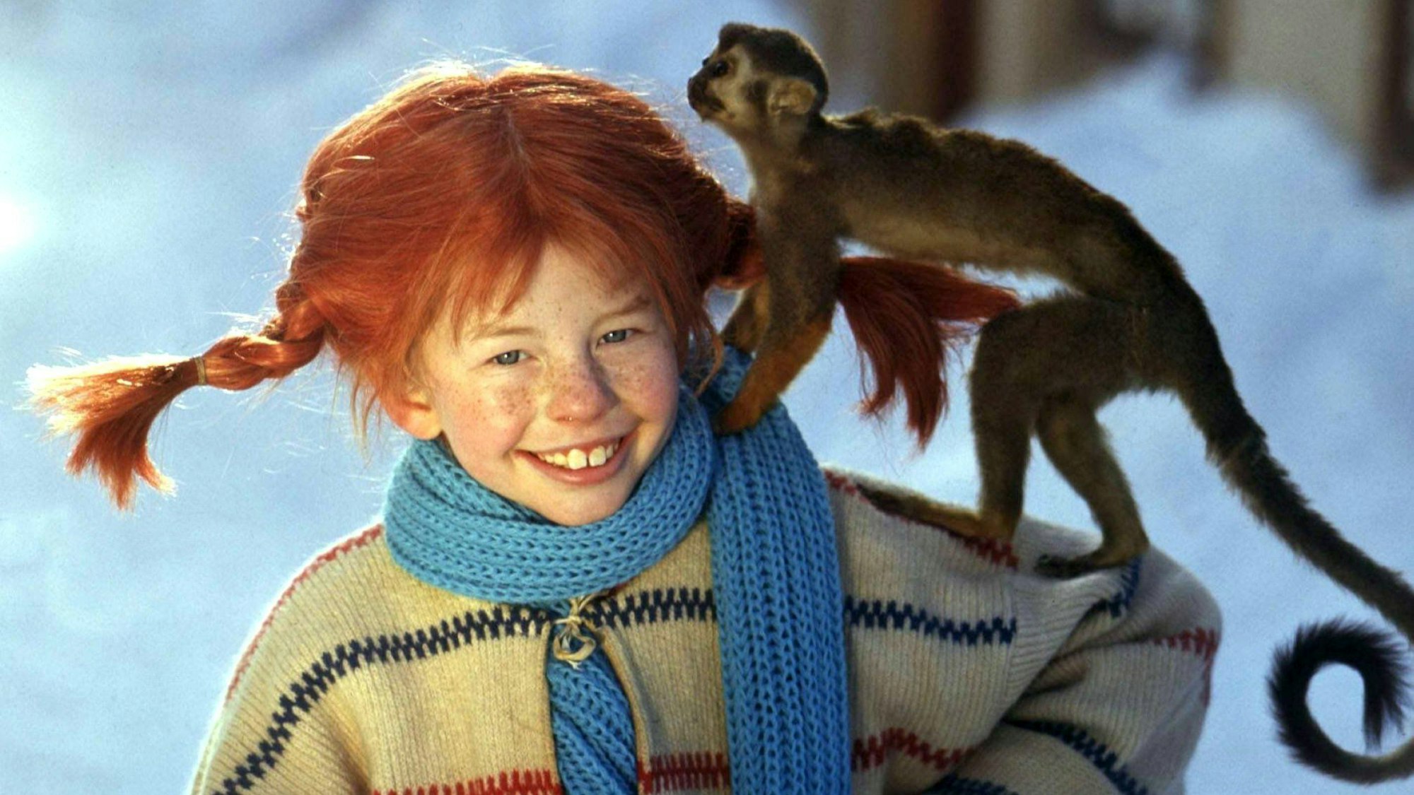 Lächelnd trägt die Schauspielerin Inger Nilsson in einem Film von 1968 als Pippi Langstrumpf an einem kalten Wintertag ihr Äffchen Herr Nilsson auf der Schulter spazieren.