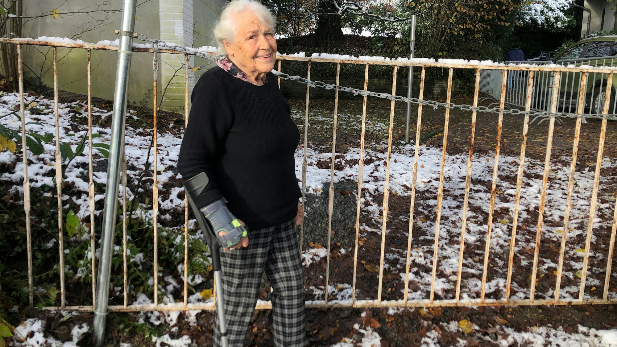 Frau Fuchs steht vor dem Absperrgitter.