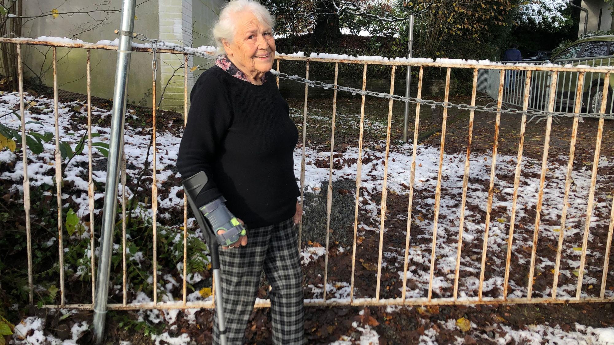 Frau Fuchs steht vor dem Absperrgitter.