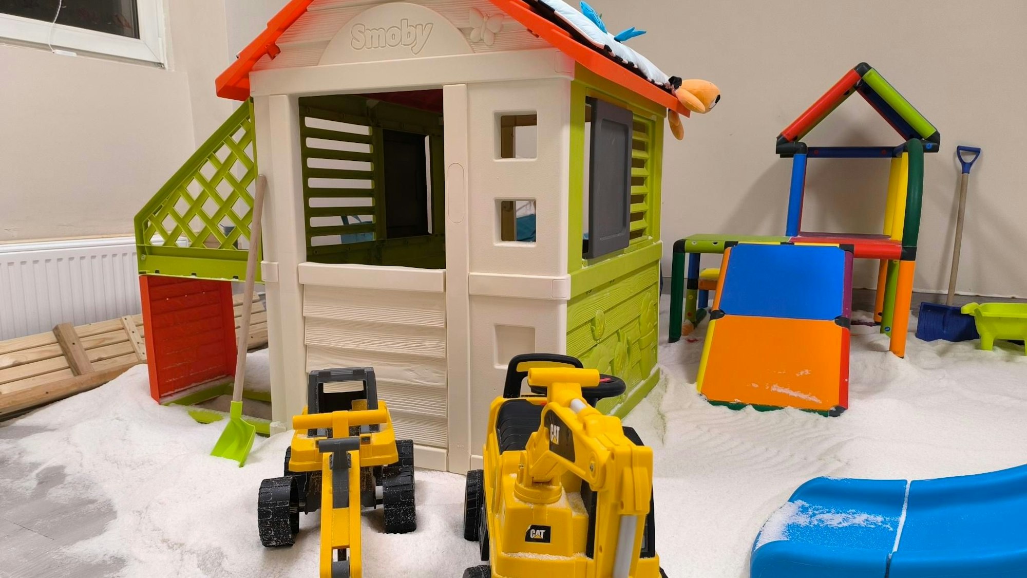 Einblick in den Salzraum des Babybeach Leverkusen. Ein paar Spielzeugbagger und ein Häuschen sind auf Salzboden zu sehen.