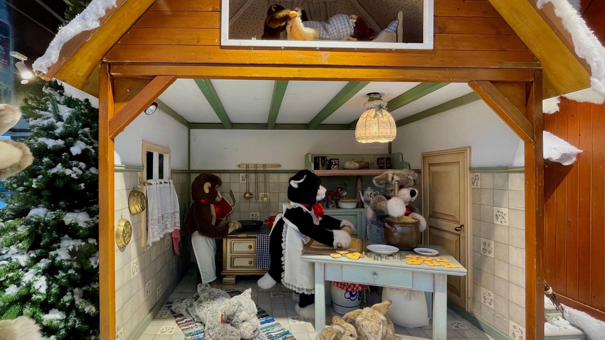 Kuscheltiere backen Kekse im Steiff-Weihnachtsfenster in Köln.