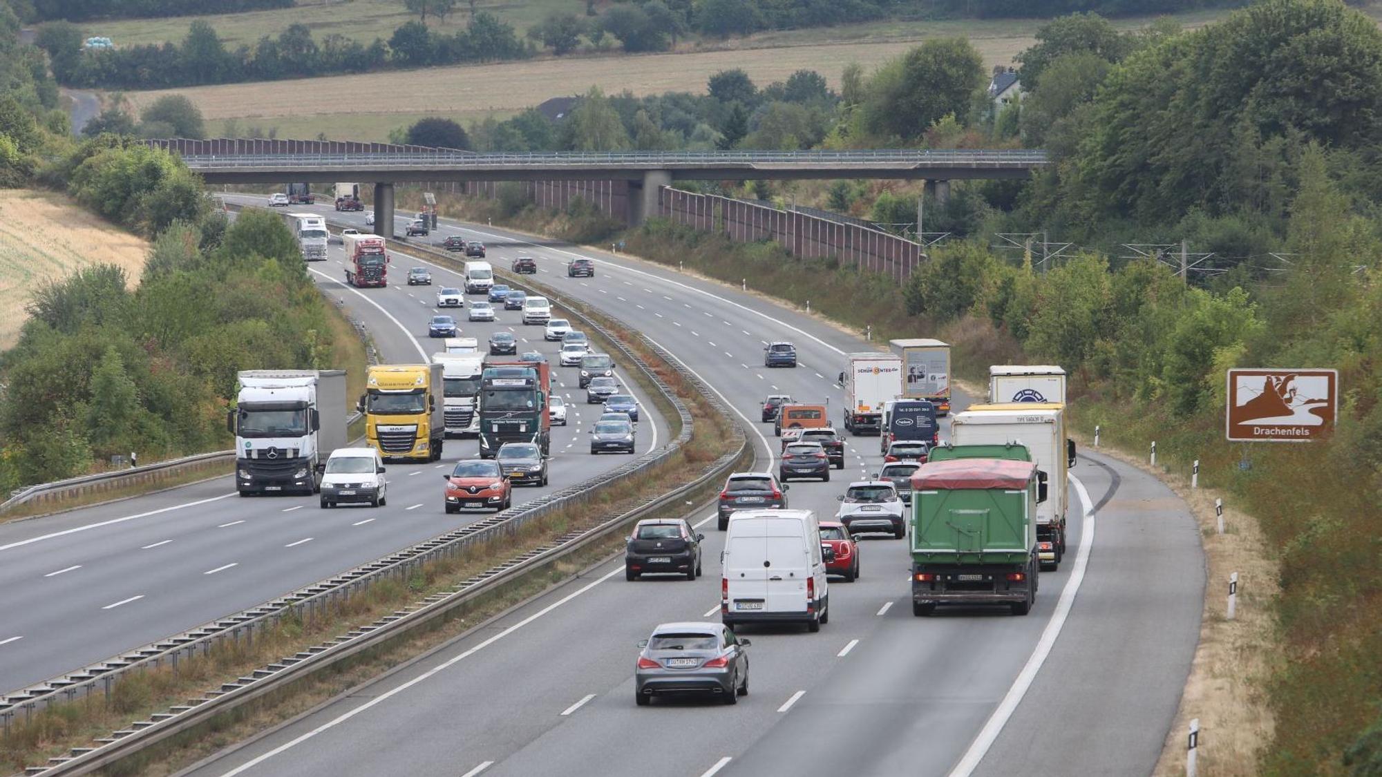 Mehrere Pkw und Lkw fahren auf der sechsspurigen Autobahn.