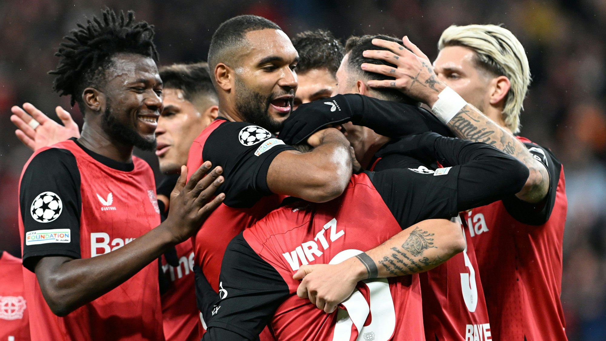 Leverkusens Spieler bejubeln das Tor zum 3:0 von Florian Wirtz (M).