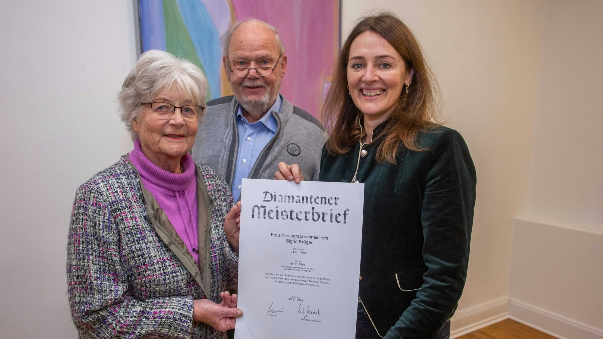 Von Waldbröls Bürgermeisterin Larissa Weber (rechts) hat Sigrid Kröger den diamantenen Meisterbrief der Handwerkskammer zu Köln erhalten, auch Ehemann Klaus freut sich darüber.