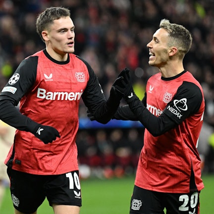 Bayer Leverkusen's German midfielder #10 Florian Wirtz (L) celebrates scoring his team's first goal with Bayer Leverkusen's Spanish defender #20 Alejandro Grimaldo during the UEFA Champions League football match Bayer 04 Leverkusen vs FC Salzburg in Leverkusen, western Germany on November 26, 2024. (Photo by INA FASSBENDER / AFP)