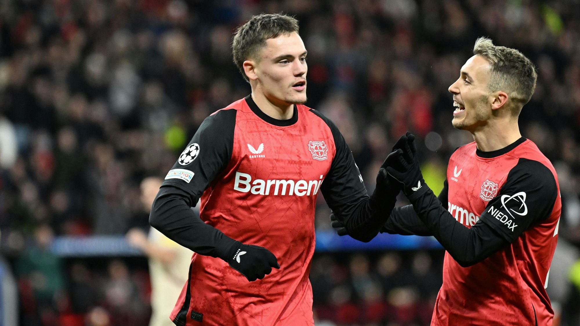 Bayer Leverkusen's German midfielder #10 Florian Wirtz (L) celebrates scoring his team's first goal with Bayer Leverkusen's Spanish defender #20 Alejandro Grimaldo during the UEFA Champions League football match Bayer 04 Leverkusen vs FC Salzburg in Leverkusen, western Germany on November 26, 2024. (Photo by INA FASSBENDER / AFP)