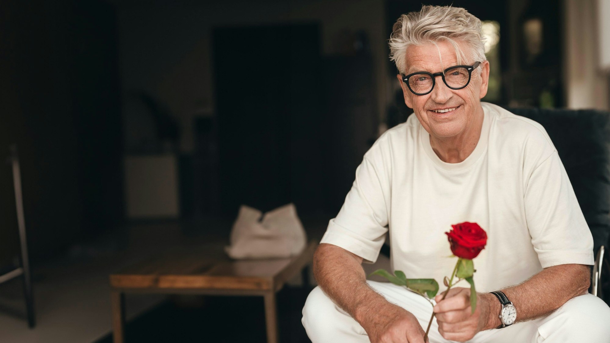 Der 73-jährige „Golden Bachelor“ Franz Stärk sucht in der RTL-Datingshow unter 18 Kandidatinnen die große Liebe. Er hält eine Rose zwischen den Fingern und lächelt in Richtung der Kamera.
