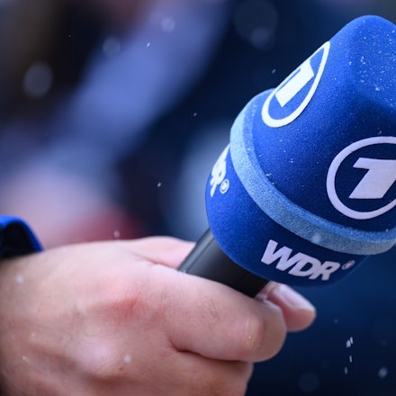 ARCHIV - 24.02.2024, Nordrhein-Westfalen, Winterberg: ILLUSTRATION - Ein Sportreporter der ARD hält ein Mikro mit dem Logo des WDR und das Erste in der Hand bei der Bob-WM. (zu dpa: «Moskau weist zwei ARD-Mitarbeiter aus») Foto: Robert Michael/dpa +++ dpa-Bildfunk +++