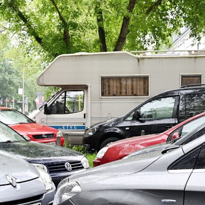 Wohnmobile und Wohnanhänger (Wohnwagen) parken am Straßenrand im öffentlichen Verkehrsraum.