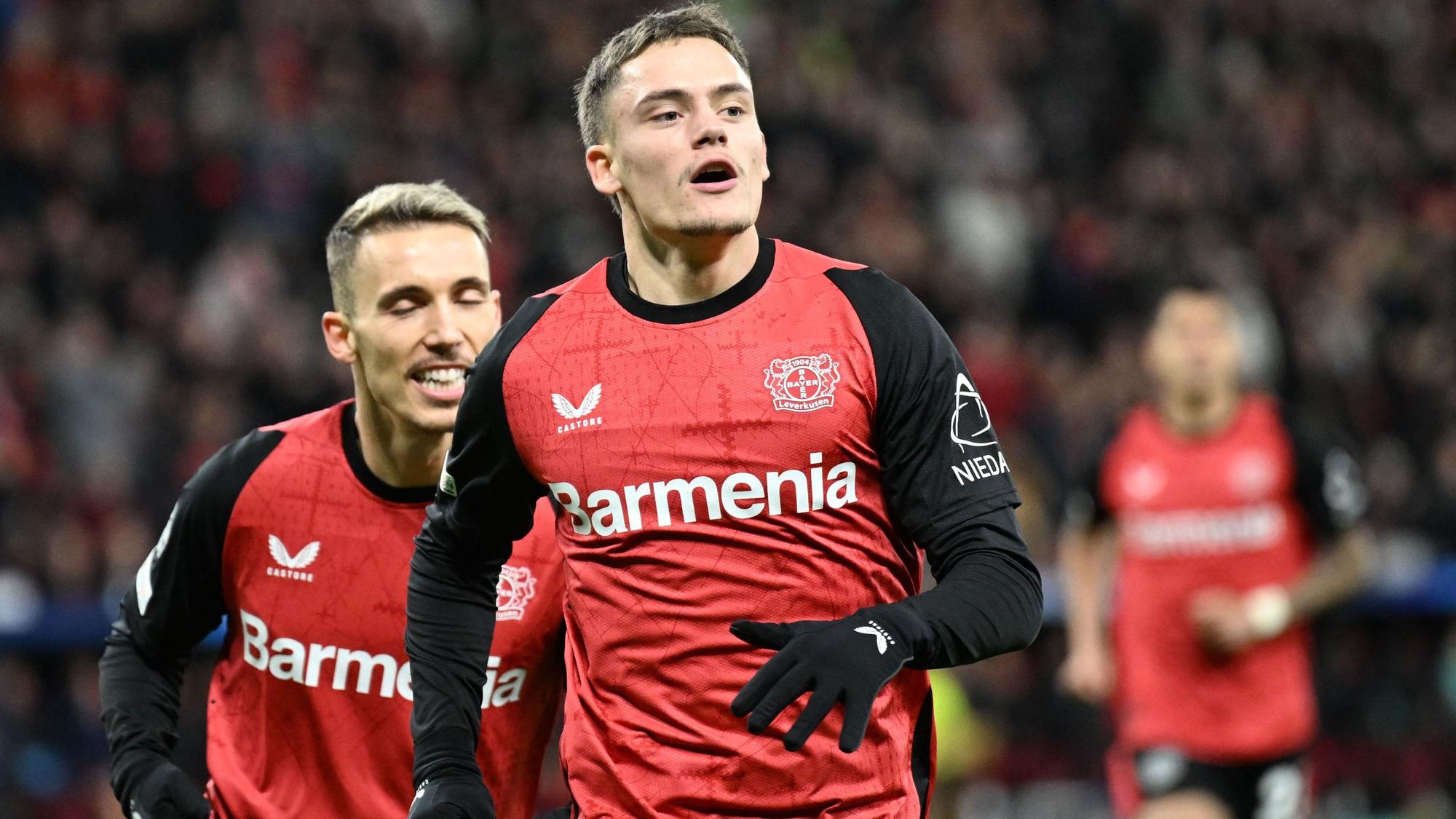 Bayer Leverkusen's German midfielder #10 Florian Wirtz (R) celebrates scoring his team's first goal with Bayer Leverkusen's Spanish defender #20 Alejandro Grimaldo during the UEFA Champions League football match Bayer 04 Leverkusen vs FC Salzburg in Leverkusen, western Germany on November 26, 2024. (Photo by INA FASSBENDER / AFP)