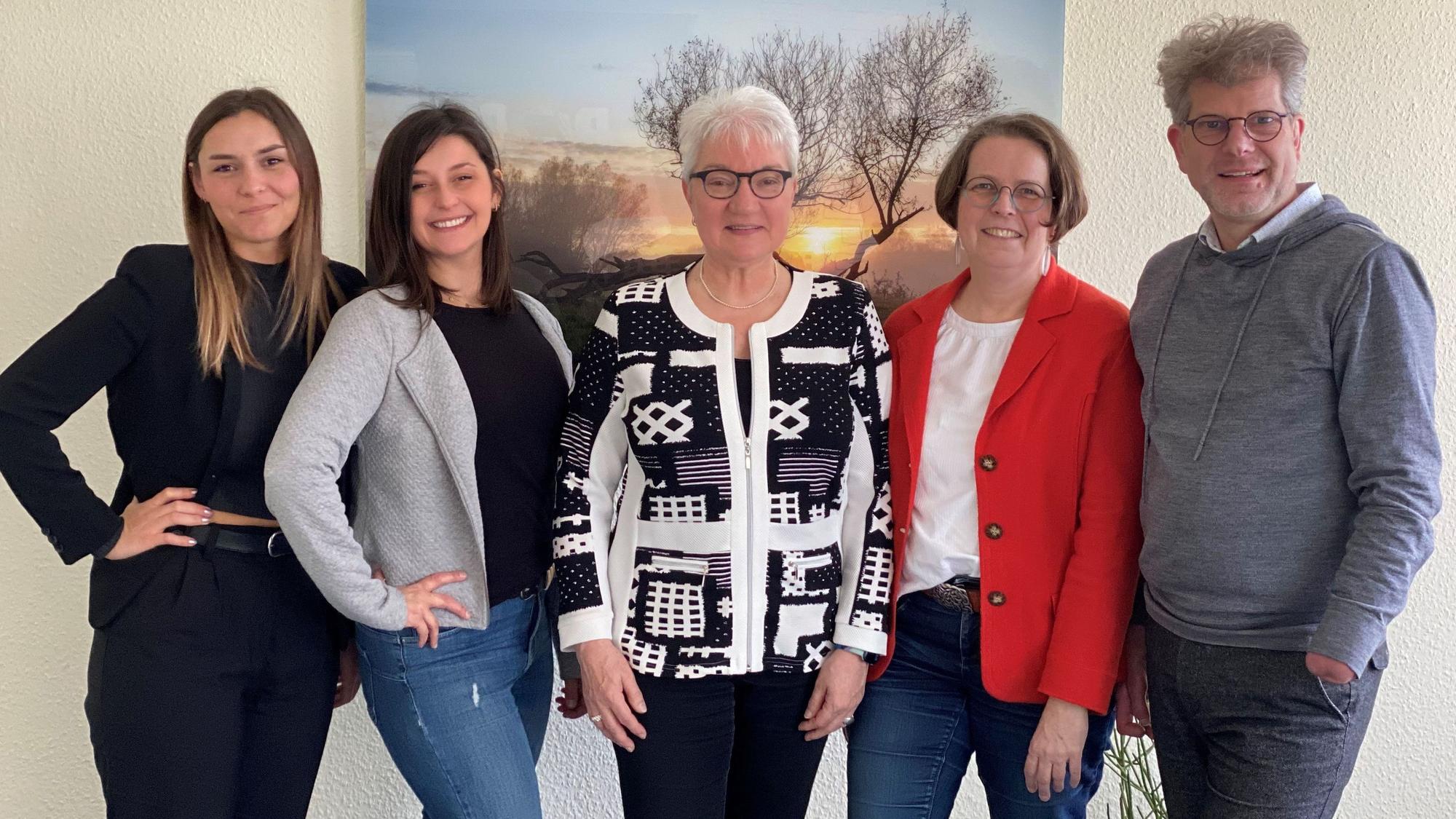 Vier Frauen und ein Mann stehen vor einem Bild