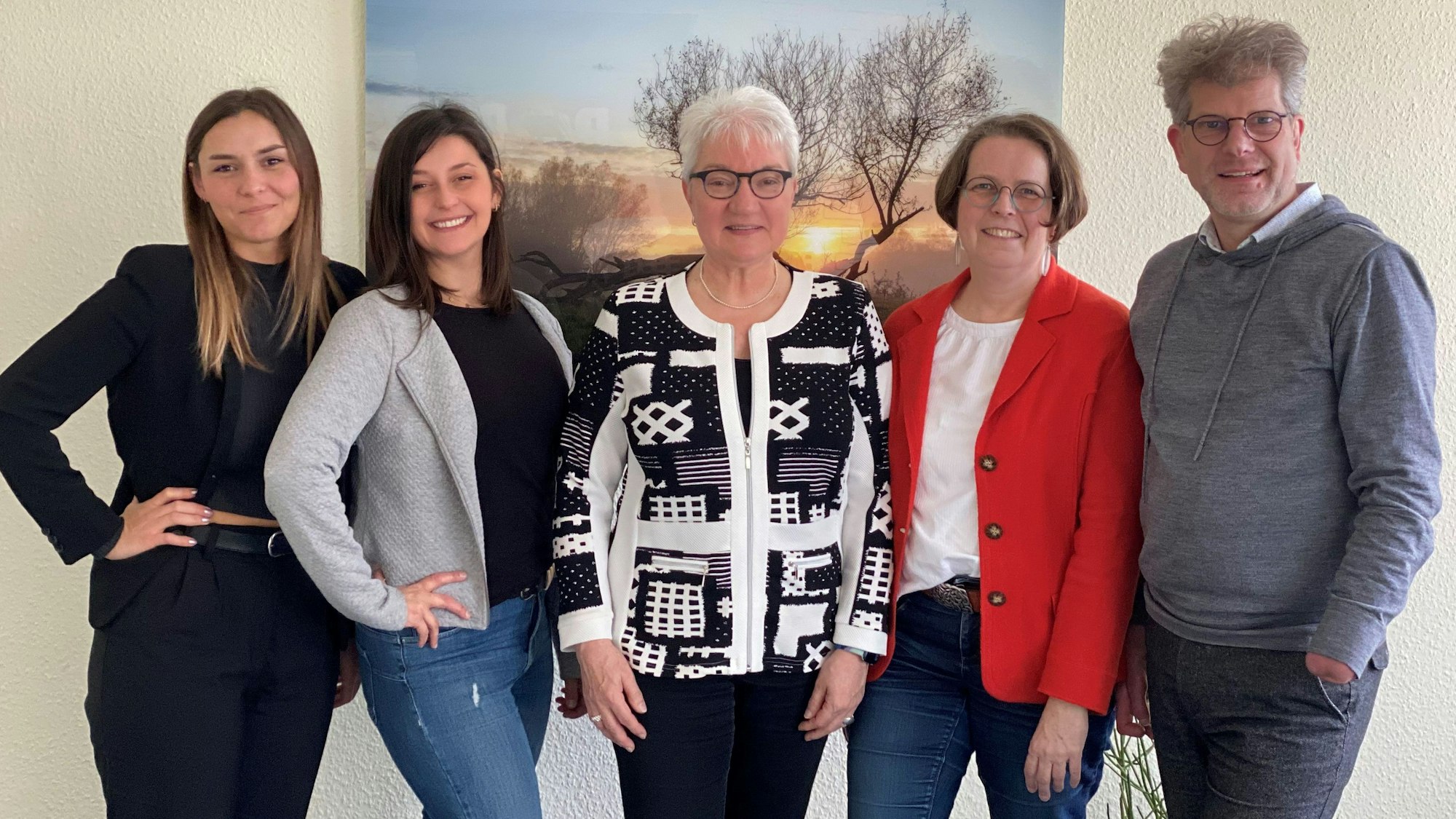 Vier Frauen und ein Mann stehen vor einem Bild