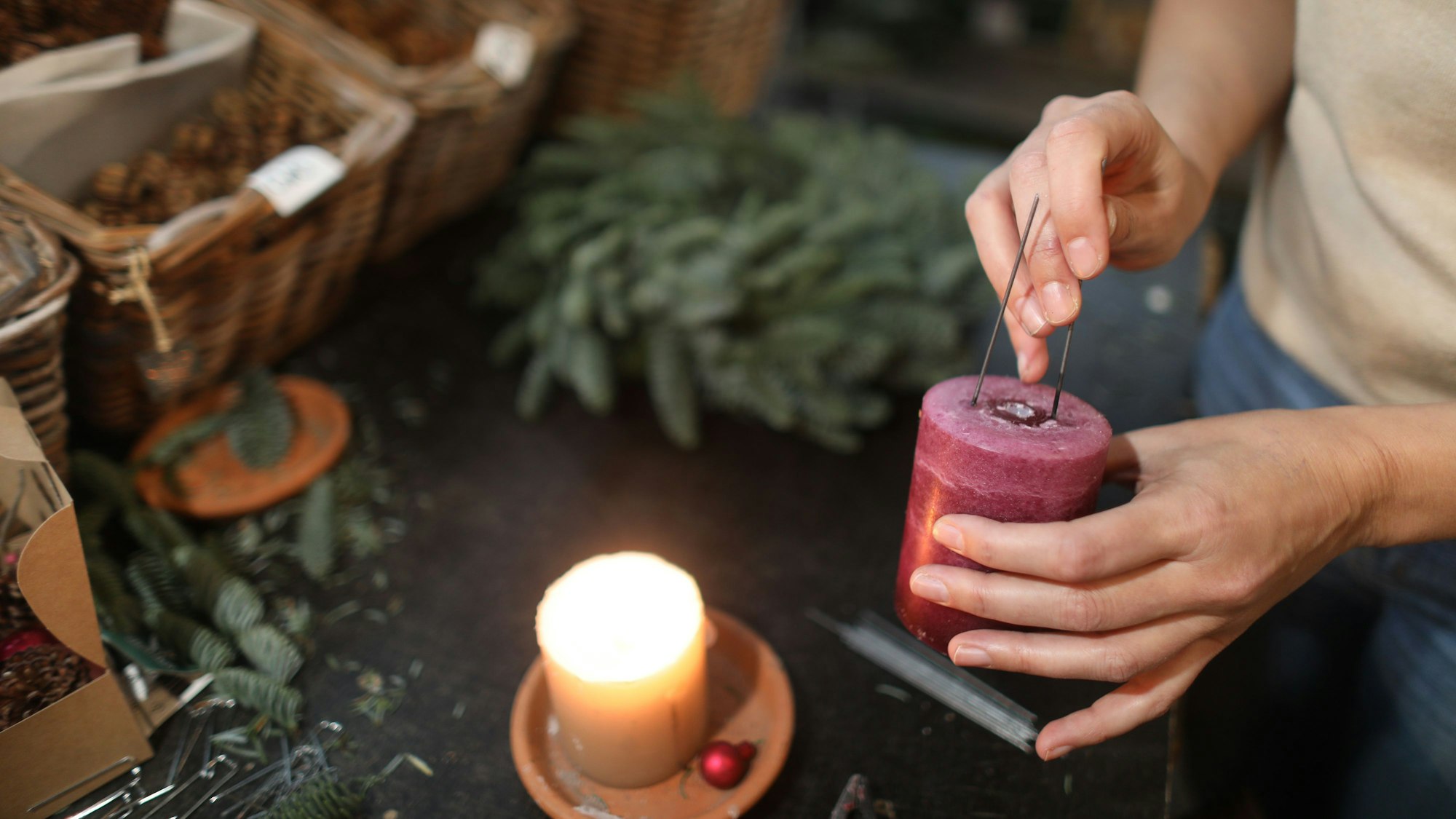 Die Drähte werden heiß gemacht, dann kann man sie einfach in die Kerze drücken.