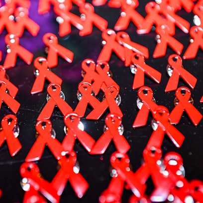 : Aids-Schleifen liegen als Anstecknadeln auf einem Tisch.