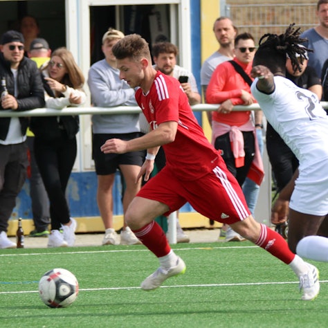 Devin Nickisch läuft an einem Gegenspieler vorbei, im Hintergrund Zuschauer.