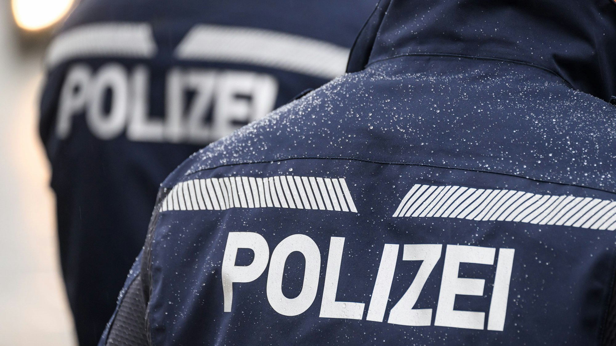 Ein Polizist steht während einer Kontrolle an einer Straße.