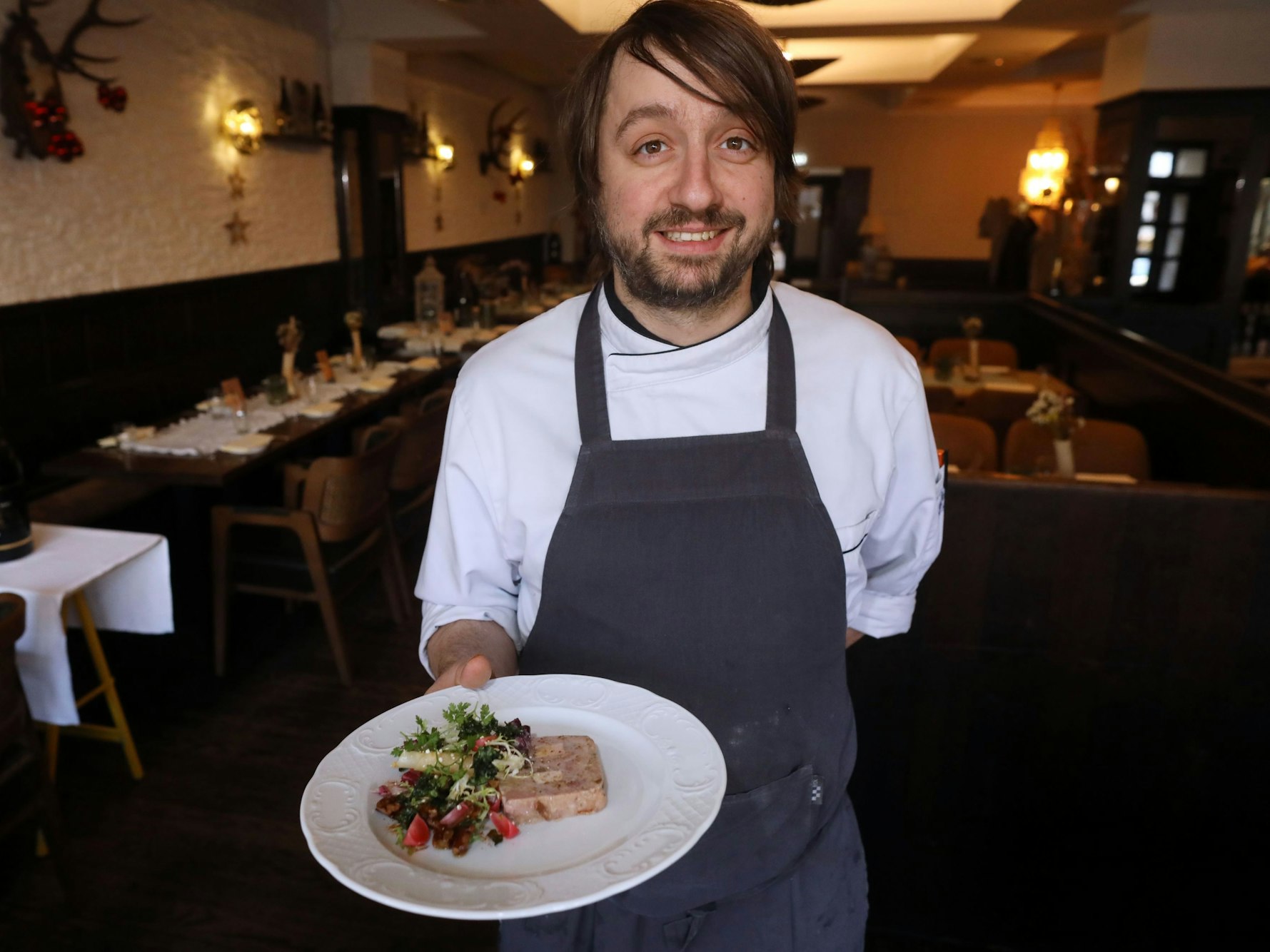 Michael Scherz, Koch und Inhaber des Gasthauses, serviert die Schweinderlterrine