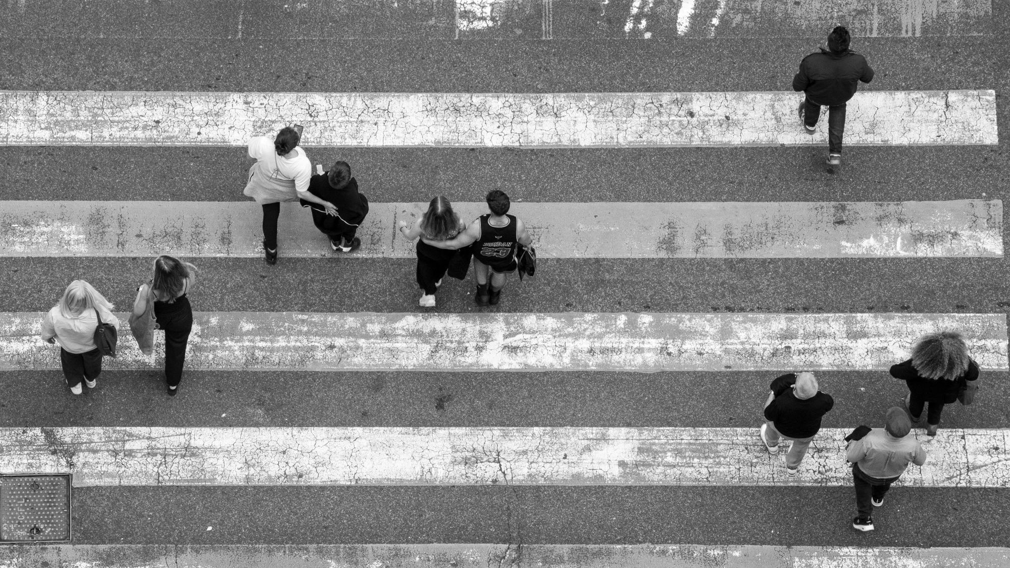 Menschen laufen über einen Zebrastreifen.