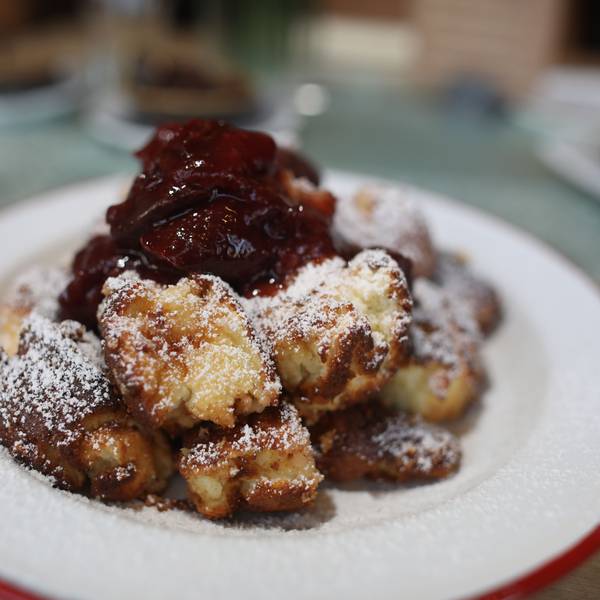 Auf einem Teller werden Kaiserschmarrn und Zwetschgenröster serviert.