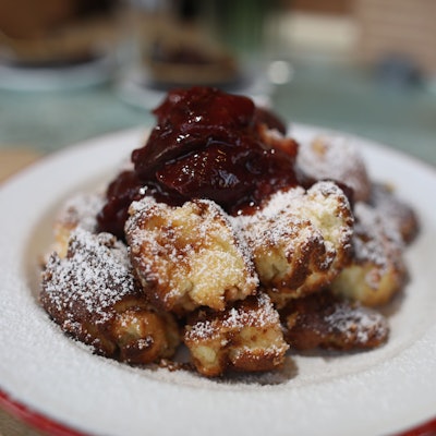Auf einem Teller werden Kaiserschmarrn und Zwetschgenröster serviert.