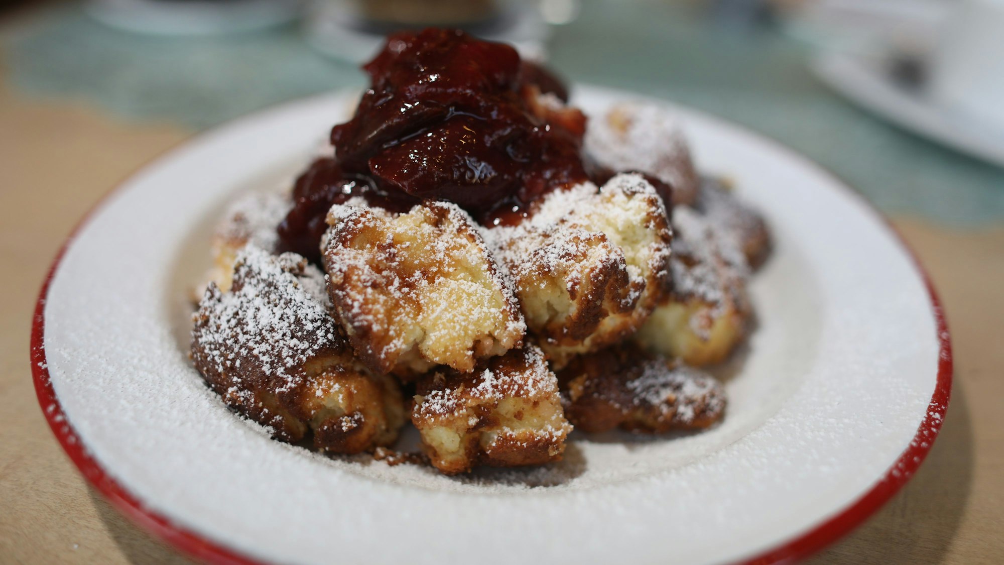 Auf einem Teller werden Kaiserschmarrn und Zwetschgenröster serviert.