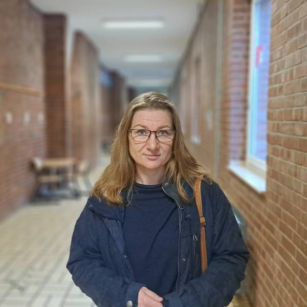 Eine Frau steht in einem Flur eines Schulgebäudes