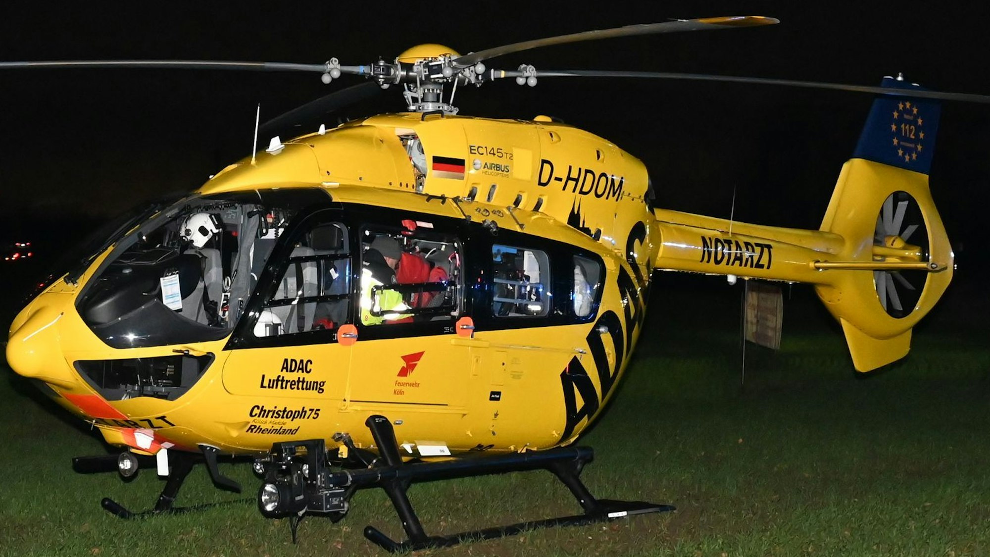 Das Bild zeigt einen Rettungshubschrauber neben einem Weg.