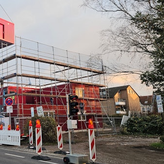 Ein Mobilkran hievt Container aufeinander, eine Unterkunft für Geflüchtete entsteht.