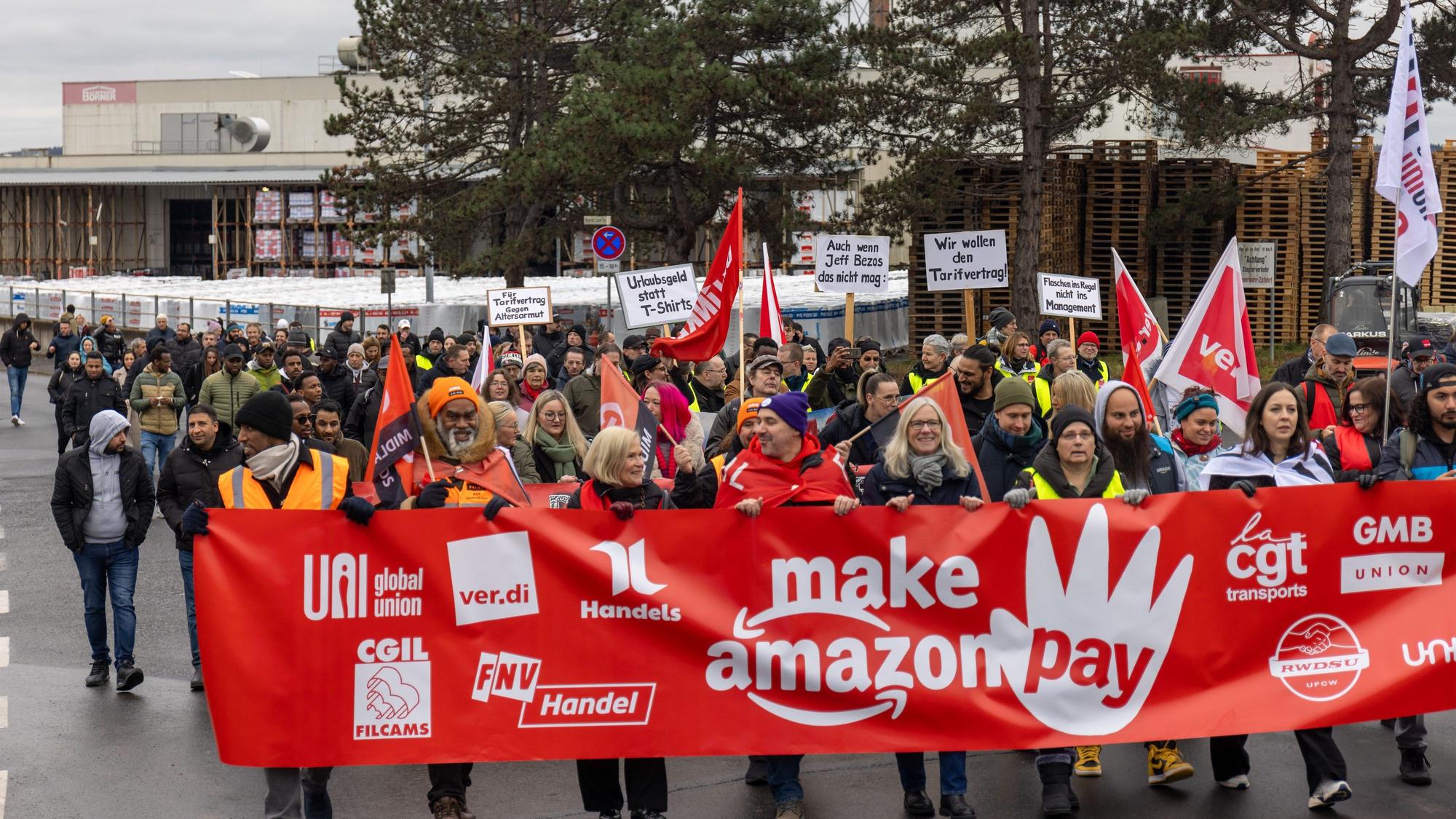29.11.2024, Hessen, Bad Hersfeld: Anlässlich des Rabatt-Tages Black Fridays streiken etwa 400 bis 500 Amazon-Beschäftigte aus dem Bundesgebiet mit Kollegen aus den USA, Schweden, Großbritannien und Italien im internationalen Protestzentrum in Bad Hersfeld. Gemeinsam ziehen sie in zwei Demonstrationszügen durch die Innenstadt, um auf die unfairen Arbeitsbedingungen und die Tariflosigkeit beim Amazon-Konzern aufmerksam zu machen. Organisiert wurde die Aktion von der Vereinten Dienstleistungsgewerkschaft (ver.di) und dem Weltdachverband der Dienstleistungsgewerkschaften UNI Global Union.