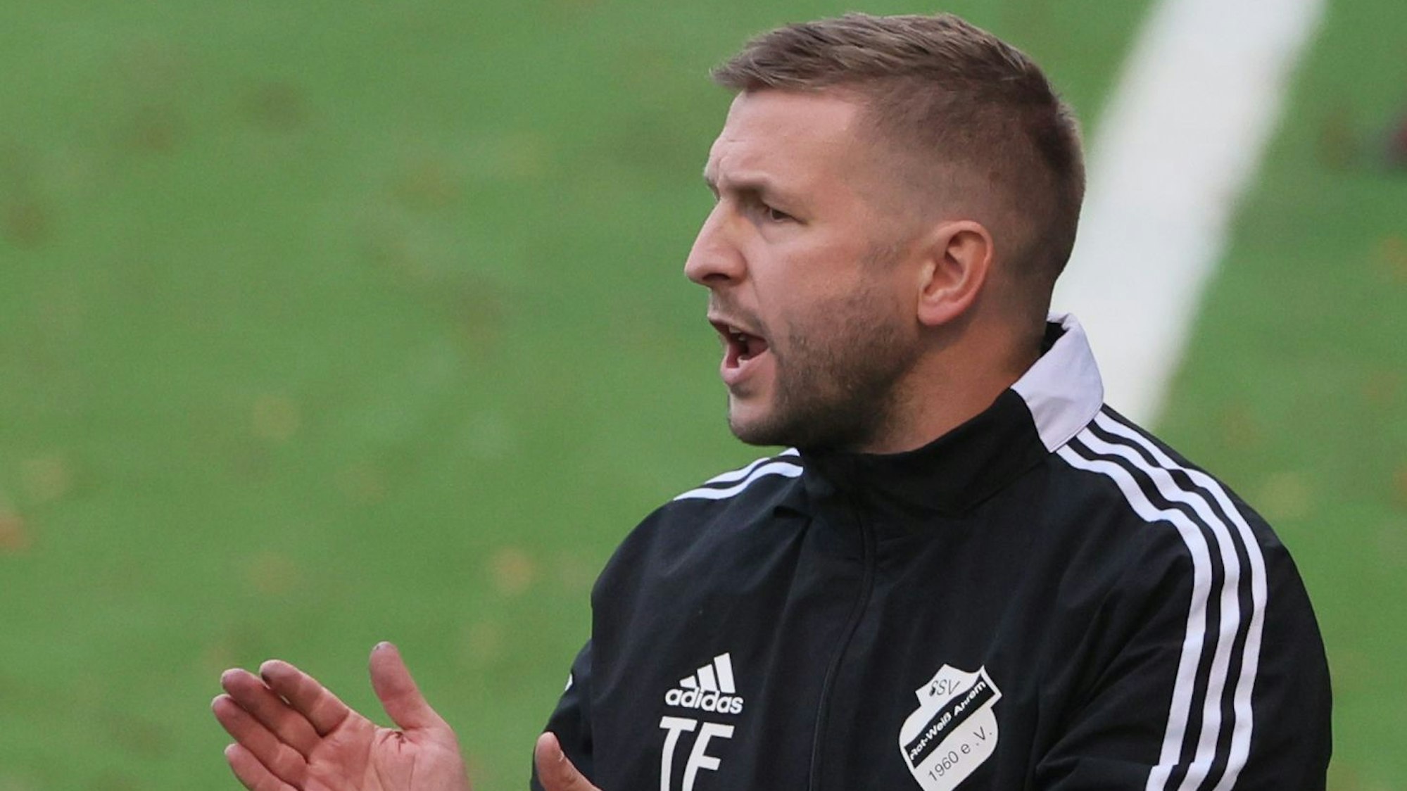 Zu sehen ist Thomas Frohn, Trainer von RW Ahrem, im Trainingsanzug am Spielfeldrand.